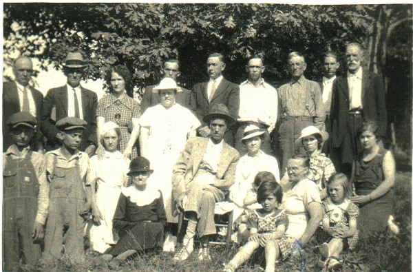 The man in the chair is my grandfather, John William Patrick. The lady sitting in the middle of the children on the right is my grandmother, Anna Delitha (Barnes) Patrick. The three little girls are my sisters. The lady kneeling on the right side of the picture is my mother, Sylvia (Salvia) V. (Whiteman) Patrick. The lady next to her is Mavis (Patrick) Powell, my Dad's youngest sister. Can anyone identify the other people in this group?