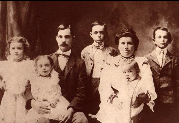 Lillian, Mamie (also called Betsy, in TJ's lap), Thomas Jefferson., Grant Evan, Stella, Herbert (baby in Stella's lap), and Millard.